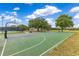 Community basketball court and tennis court with mature trees and blue skies at 10142 Hidden Dunes Ln, Orlando, FL 32832