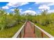 Community boardwalk winding through a lush green area under a sunny sky at 10142 Hidden Dunes Ln, Orlando, FL 32832
