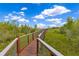 Community boardwalk winding through a grassy marsh under a sunny sky at 10142 Hidden Dunes Ln, Orlando, FL 32832
