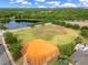 Aerial view of the community baseball field and pond with school nearby at 10142 Hidden Dunes Ln, Orlando, FL 32832