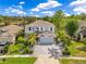Beautiful, two-story light-blue home with palm trees and a brick driveway and sidewalk at 10142 Hidden Dunes Ln, Orlando, FL 32832