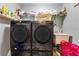 Laundry room featuring modern washer and dryer, utility sink, and shelving at 10142 Hidden Dunes Ln, Orlando, FL 32832
