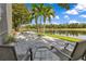 Outdoor patio with peaceful water views offers a serene retreat with chairs, a hammock, and tropical plants for relaxation at 10142 Hidden Dunes Ln, Orlando, FL 32832