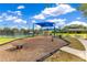Community playground featuring play equipment, a picnic shelter, and tennis courts at 10142 Hidden Dunes Ln, Orlando, FL 32832