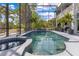 Inviting screened-in pool and spa area surrounded by lush greenery and mature landscaping for a private outdoor experience at 10142 Hidden Dunes Ln, Orlando, FL 32832
