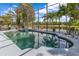 Beautiful screened-in pool and spa overlooking a tranquil lake with lush tropical landscaping and ample space for outdoor entertaining at 10142 Hidden Dunes Ln, Orlando, FL 32832