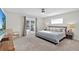 Bright bedroom featuring carpet floors, ceiling fan, double doors, and large bed with plush pillows at 105 Spring Cove Trl, Altamonte Springs, FL 32714