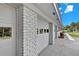 Side view of a white brick garage with panel doors and a well-manicured lawn at 105 Spring Cove Trl, Altamonte Springs, FL 32714