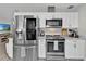 Modern kitchen with stainless steel appliances, white cabinets, and marble countertops at 105 Spring Cove Trl, Altamonte Springs, FL 32714