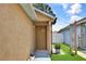 Inviting front entryway features a brown front door, manicured lawn, and decorative potted plant at 107 Pamala Ct, Sanford, FL 32771