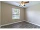 Sunlit bedroom features wood-look plank flooring and a ceiling fan at 113 Venetian Bay Cir, Sanford, FL 32771