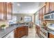 Kitchen featuring stainless steel appliances and wood cabinetry leading into a dining area with views to the pool at 113 Venetian Bay Cir, Sanford, FL 32771
