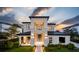 Striking modern two-story home with black-trimmed windows and manicured landscaping at sunset at 11303 Windermere Rd, Windermere, FL 34786