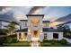 Modern two-story home boasts a clean design, well-manicured lawn, and elegant black framed windows at 11303 Windermere Rd, Windermere, FL 34786
