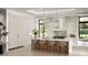 Elegant white kitchen featuring marble countertops, sleek cabinetry, and modern pendant lighting at 11303 Windermere Rd, Windermere, FL 34786