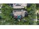 An aerial view showcases a private backyard with a swimming pool, spa, and lush greenery at 11415 N Camden Commons Dr, Windermere, FL 34786