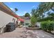 Relaxing backyard patio with a grill, seating under a red umbrella, and lush green landscaping at 11415 N Camden Commons Dr, Windermere, FL 34786