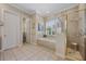 Bright bathroom featuring a soaking tub, tile floors, and a separate shower at 11415 N Camden Commons Dr, Windermere, FL 34786