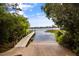 Community boat ramp leading to a serene lake with lush greenery and distant waterfront homes at 11415 N Camden Commons Dr, Windermere, FL 34786