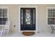 Elegant front door with glass detailing and sidelights, complemented by a rocking chair at 11415 N Camden Commons Dr, Windermere, FL 34786