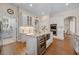 Well-lit kitchen with an island, white cabinets, stainless steel appliances, and wooden flooring at 11415 N Camden Commons Dr, Windermere, FL 34786