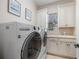 Bright laundry room with a utility sink, white cabinets, and washer and dryer at 11415 N Camden Commons Dr, Windermere, FL 34786