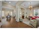 Open-concept home featuring elegant columns, wood flooring, a chandelier, and a comfortable living area at 11415 N Camden Commons Dr, Windermere, FL 34786
