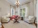 Bright living room with cozy seating, chandelier lighting, and large windows offering natural light at 11415 N Camden Commons Dr, Windermere, FL 34786