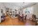 Open-concept living area with wood flooring, ceiling fan, fireplace, and adjoining dining space at 11415 N Camden Commons Dr, Windermere, FL 34786