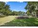 A sunny playground with swings sits on a green lawn under a bright blue sky at 11415 N Camden Commons Dr, Windermere, FL 34786