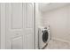 Laundry room with a modern washer and dryer, complemented by a wire shelf for storage at 11993 Charades St, Orlando, FL 32832