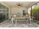 Covered patio featuring an outdoor dining area with a ceiling fan and a well-equipped outdoor kitchen at 11993 Charades St, Orlando, FL 32832