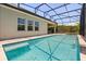 Screened-in pool area featuring a sparkling pool, lounge chairs, and lush landscaping for privacy at 11993 Charades St, Orlando, FL 32832
