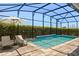 Private screened-in pool features a waterfall feature, lounge chairs and lush landscaping for a relaxing backyard experience at 11993 Charades St, Orlando, FL 32832