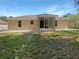 A home's backyard featuring a screened lanai and a simple lawn area and concrete patio at 131 Pecan Pass, Ocala, FL 34472