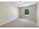 Cozy bedroom with a plush carpet, a window overlooking the yard, and fresh neutral paint throughout at 131 Pecan Pass, Ocala, FL 34472