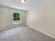 Bright bedroom featuring plush carpeting, a window view of the yard, and neutral paint, creating a serene atmosphere at 131 Pecan Pass, Ocala, FL 34472