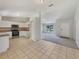 Bright, open-concept kitchen features tile flooring and modern appliances, seamlessly connecting to the carpeted living area at 131 Pecan Pass, Ocala, FL 34472
