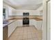 Well-lit kitchen featuring stainless steel appliances, white cabinets, and tile flooring at 131 Pecan Pass, Ocala, FL 34472