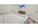Bedroom featuring a dresser, flat screen television, and a queen bed with white bedding and wood floors at 13415 Blue Heron Beach Dr # 409, Orlando, FL 32821