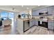 A modern kitchen with stainless steel appliances, wood floors, stone countertops, and views of the living area at 13415 Blue Heron Beach Dr # 409, Orlando, FL 32821