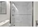 Modern bathroom with a glass-enclosed shower featuring marble-look tiles and a white hexagon-tiled floor at 13415 Blue Heron Beach Dr # 409, Orlando, FL 32821