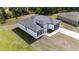 Aerial view of a modern single-Gathering home showcasing its roof, backyard, and paved driveway at 13621 Sw 40Th Cir, Ocala, FL 34473