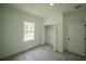 Bright bedroom features a window, closet, and light gray wood-look floors at 13621 Sw 40Th Cir, Ocala, FL 34473