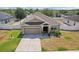 Aerial view of home showcasing the front yard, driveway, and manicured landscaping at 140 Highland Meadows St, Davenport, FL 33837