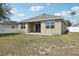 Wide view of backyard featuring lush green grass, white fencing, and covered patio at 140 Highland Meadows St, Davenport, FL 33837
