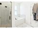 Bright bathroom featuring a glass shower, soaking tub, and modern white tile at 140 Highland Meadows St, Davenport, FL 33837
