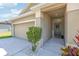 Inviting entryway with a covered porch and a two-car garage and well manicured landscape at 140 Highland Meadows St, Davenport, FL 33837