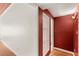 Hallway with hardwood floors, fresh white trim, and painted red accent wall with built in display shelves at 141 S Lawsona Blvd, Orlando, FL 32801