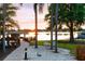 Peaceful lakeside backyard featuring a dock, beach, and idyllic sunset views at 141 S Phelps Ave, Winter Park, FL 32789